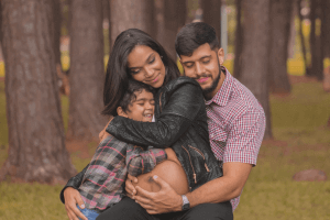 Expecting Woman, Man and Child Embracing