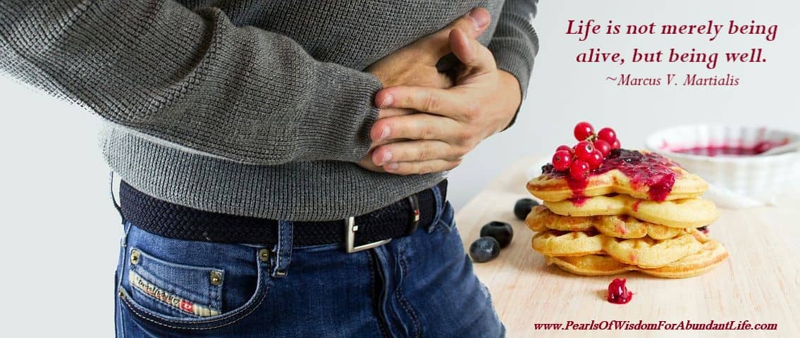 Man holding stomach beside food